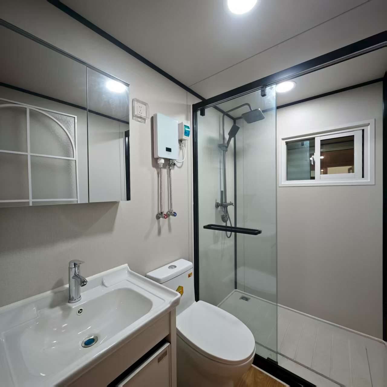 Baño real con ducha, lavabo e inodoro en Nomi Base